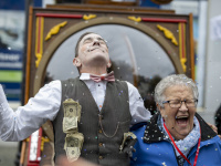 Schauspieler mit Geldscheinen jubelt neben lachender Frau