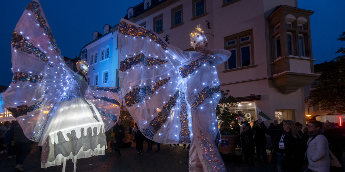 Festmeile der Landeshauptstadt beim Tag der Deutschen Einheit 2025 Zwei Stelzenläufer in leuchtenden Kostümen bei Nacht