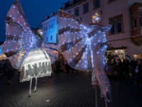 Zwei Stelzenläufer in leuchtenden Kostümen bei Nacht
