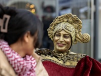 Frau im Gespräch mit lebender Statue auf Sofa