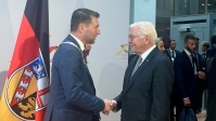 OB Uwe Conradt und Bundespräsident Frank-Walter Steinmeier schütteln sich die Hände, dahinter eine Saarland-Flagge