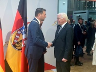 OB Uwe Conradt und Bundespräsident Frank-Walter Steinmeier schütteln sich die Hände, dahinter eine Saarland-Flagge