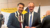 OB Uwe Conradt und Bundeskanzler Friedrich Merz stehen nebeneinander und lächeln