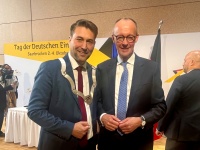 OB Uwe Conradt und Bundeskanzler Friedrich Merz stehen nebeneinander und lächeln
