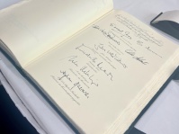 Eine Seite in einem Buch indem ein Grußwort und mehrere Signaturen stehen. Es sind die Unterschriften der obersten Bundesorgane, des französischen Staatspräsidenten und der Ministerpräsidentin.