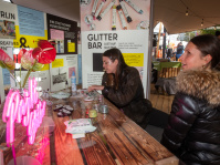 Besucherinnen lassen sich an der „Glitter Bar“ schminken, kreativer Stand im Berlin-Pavillon.