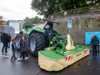 Großer grüner Landmaschinen-Traktor mit Mähwerk der Marke Krone, Besucherfamilien betrachten das Fahrzeug.