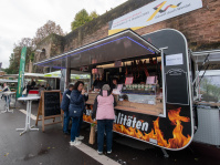 Foodtruck mit regionalen Spezialitäten aus Brandenburg, Besucher kaufen Rauchwurst und Schinken.