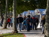 Festmeile mit Pavillons der Bundesministerien, Besucher spazieren zwischen den weißen Zelten, Lichterketten hängen in den Bäumen.