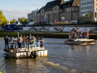 Zwei THW-Fähren mit Besuchern setzen auf der Saar über, Einsatzkräfte in blauen Uniformen begleiten die Fahrt.