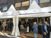 Zelt des Hauptzollamts Saarbrücken mit Infoständen und Plakaten, mehrere Personen im Gespräch.