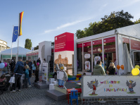 Eingangsbereich eines Kinderbereichs beim Deutschen Bundestag mit bunten Luftballons, Figuren und Besuchern.
