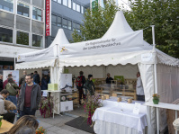 Zelt mit Aufschrift „Die Regionalmarke für den Landkreis Neunkirchen“ mit Verkaufsständen und Besuchern davor.