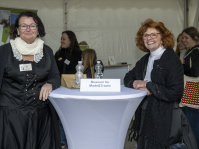 Zwei Frauen in historischer Kleidung am Stand des Museums für Mode und Tracht, im Hintergrund weitere Besucher.