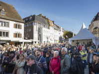 Publikum, dicht gedrängt, im Hintergrund ein Zelt mit spitzem Dach und historische Gebäude
