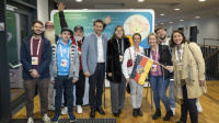 Eine Gruppe Menschen posiert vor einer Tafel für ein Gruppenbild 