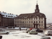 Altes Rathaus in Alt-Saarbrücken im Schnee mit parkenden Autos davor.