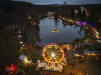Von oben zeigt sich das Riesenrad vor dem See, umgeben von weihnachtlich beleuchteten Wegen.