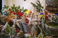 Detailaufnahme eines Verkaufsstandes mit handgefertigten Weihnachtssternen, Tannenfiguren und dekorativen Holzelementen.