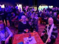 Eine Gruppe sitzender Menschen hört einer Rede zu