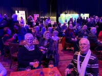 Eine Gruppe sitzender Menschen hört einer Rede zu