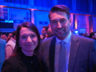 Eine Frau steht neben einem Mann, beide lächeln