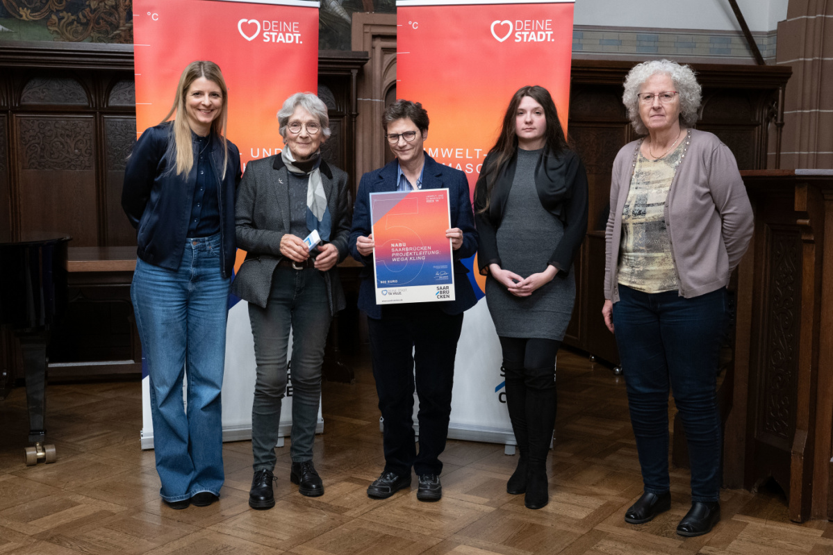 Preisträgerinnen halten Urkunde in Kamera und lächeln