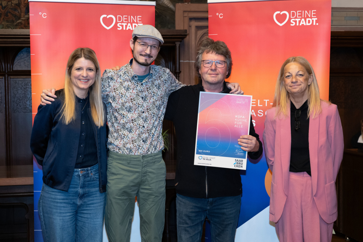 Preisträger halten Urkunde in Kamera und lächeln