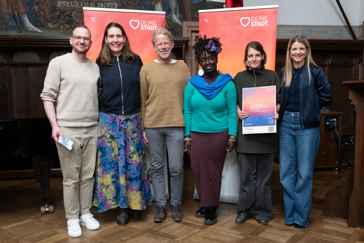 Preisträgerinnen und Preisträger halten Urkunde in Kamera und lächeln