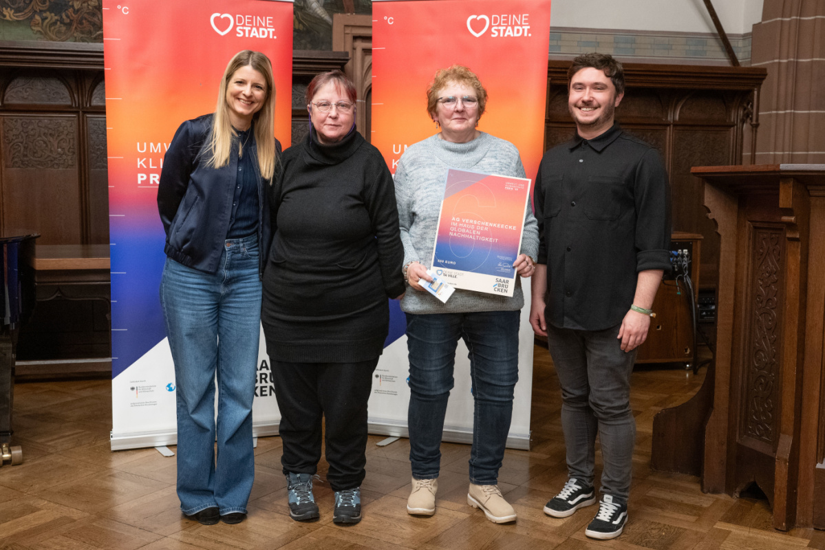 Preisträgerinnen halten Urkunde in Kamera und lächeln