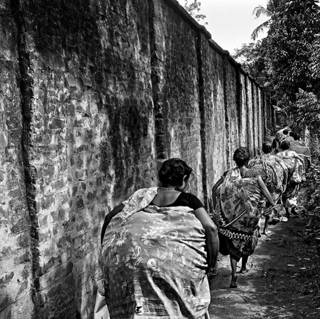 Frauen aus Bangladesh mit Waren an einer Mauer Grenze mit Indien