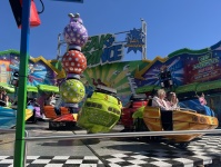 Fahrgeschäft mit bunten, runden Gondeln auf drehender Plattform