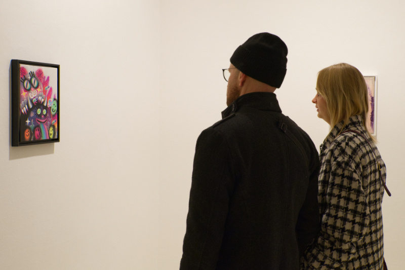 Zwei Personen schauen sich ein Gemälde in einer Ausstellung an 