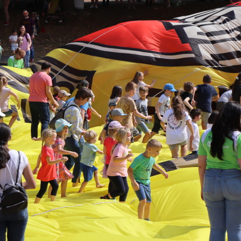 Kinder springen auf der Plane eines Heißluftballons herum
