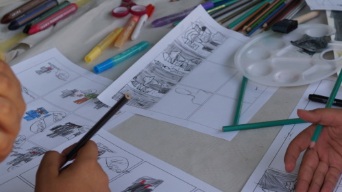 Kinderhände, Papier und Stifte auf einem Tisch