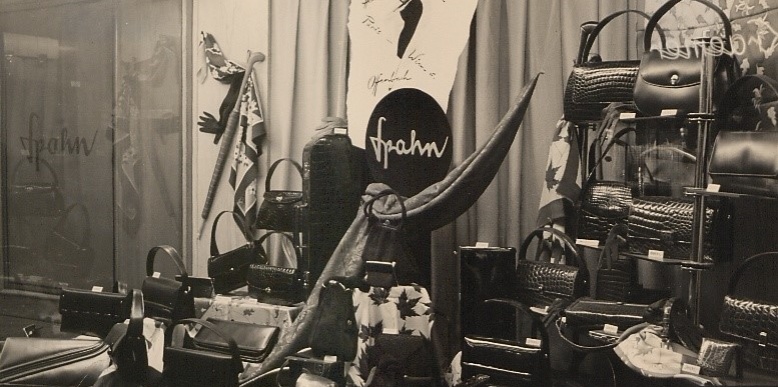 Schwarz-weiß Foto des Schaufensters von Leder Spahn aus den 1950er Jahren, in dem verschiedene Taschenmodelle ausliegen.