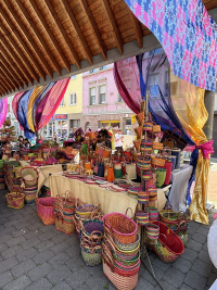 Auf einem Marktstand stehen bunte Körbe.