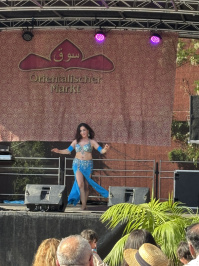 Eine Frau in blauer Kleidung tanzt auf der Bühne.