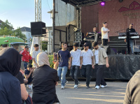 Junge Männer tanzen vor der Bühne während des Auftritts der Musikband.
