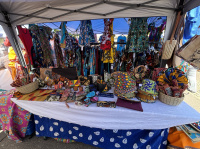 Am Stand hängen bunte afrikanische Kleider.