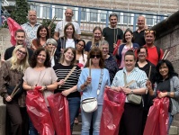 Mitarbeitende des Hauptamtes beim World Cleanup Day 2026 Gruppe von Menschen steht auf einer Treppe und hält rote Müllsäcke sowie Müllgreifer in den Händen.