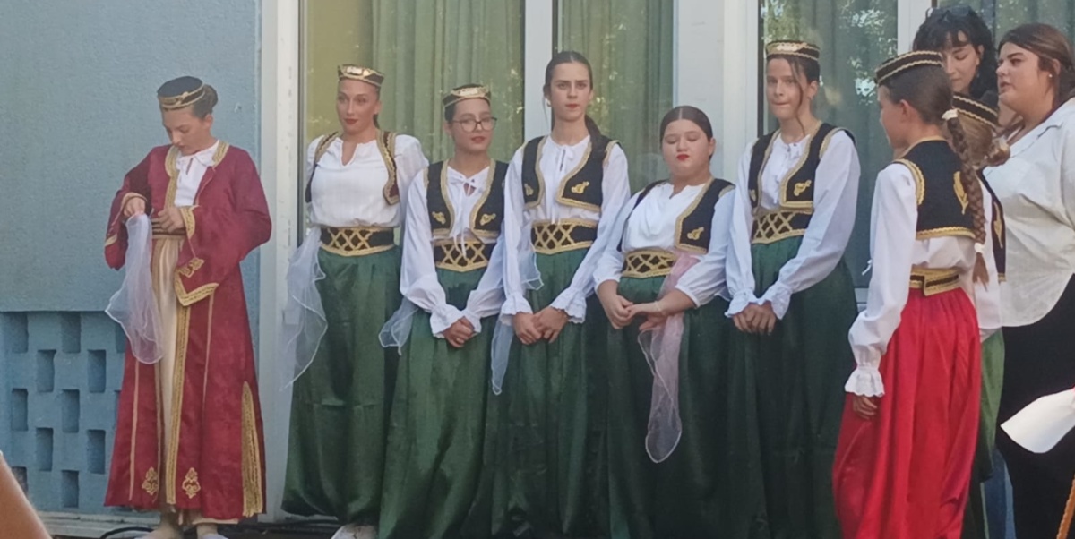 mehrere junge Leute in traditionellen bosnischen Gewändern stehen zum Tanz bereit
