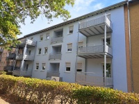 dreigeschossiges Wohnhaus mit sechs angebauten Balkonen und drei Loggien, hellblaue Fassade