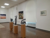 drei Skulpturen auf Säulen und drei Bilder an der Wand