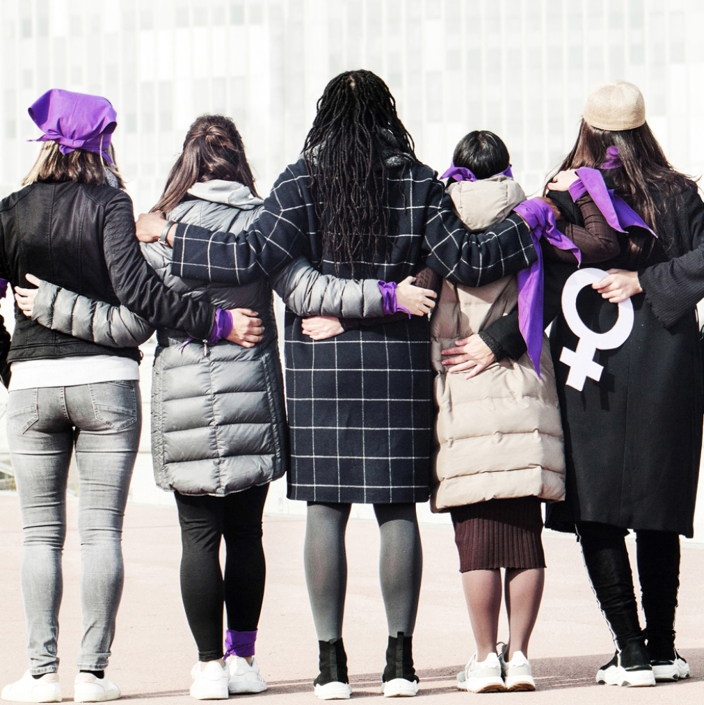 Mehrere Frauen von hinten mit Frauenzeichen auf dem Rücken